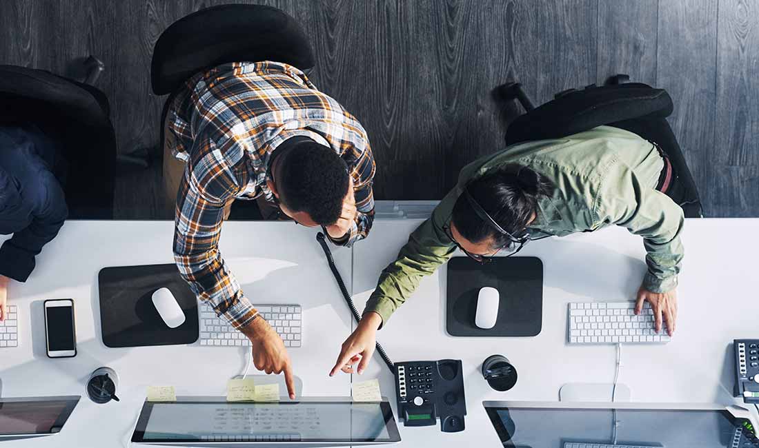 2 colegas colaborando em um computador