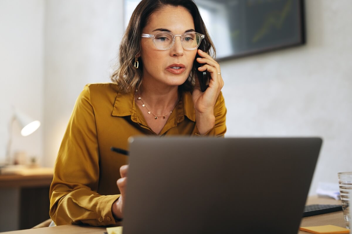office woman on the phone in front of a laptop