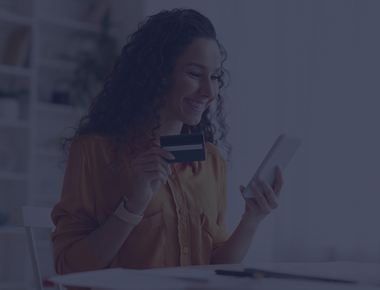 Mulher sorrindo ao telefone fazendo um pagamento